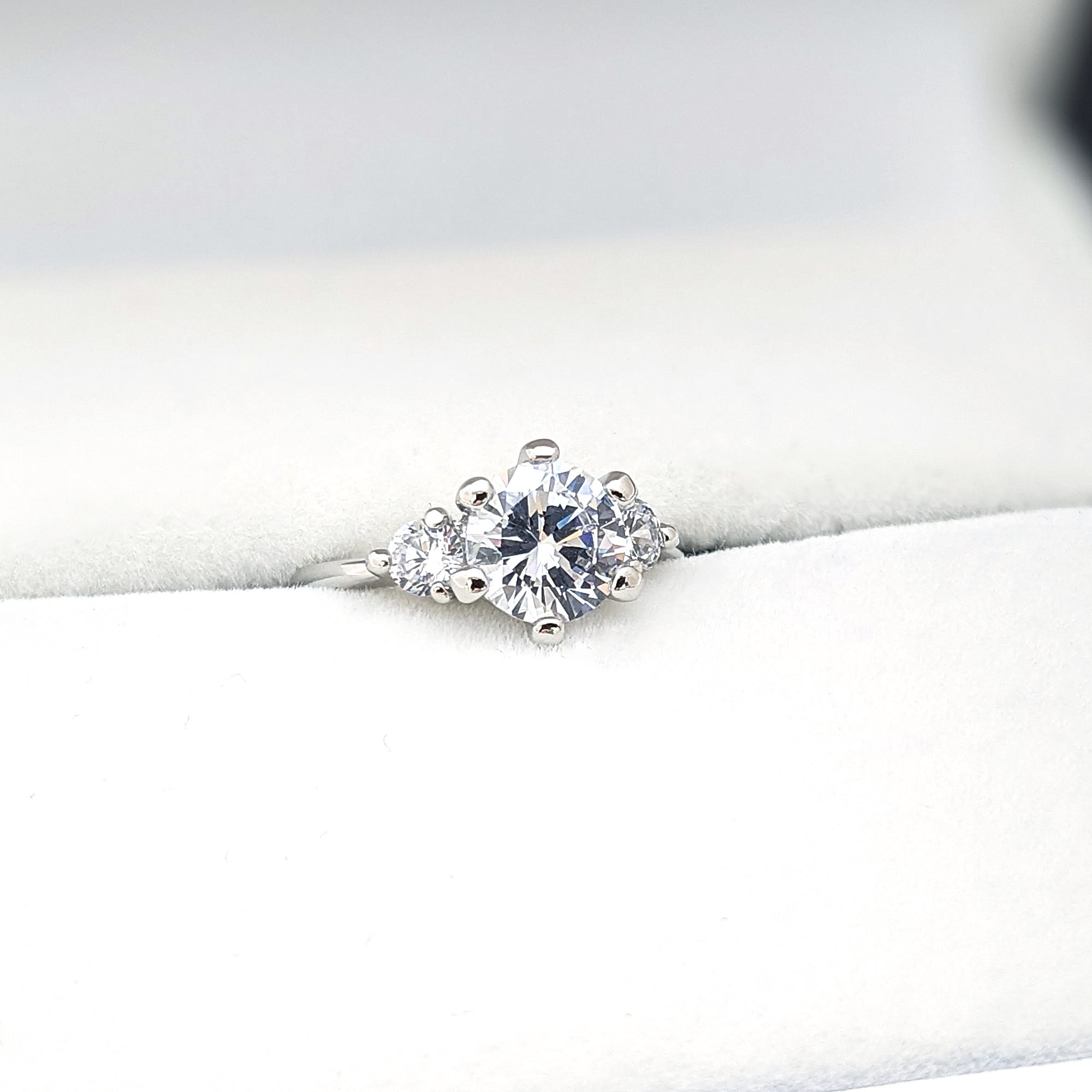 ２カラットダイヤモンドと両側にもダイヤモンドを留めたスリーストーンの婚約指輪