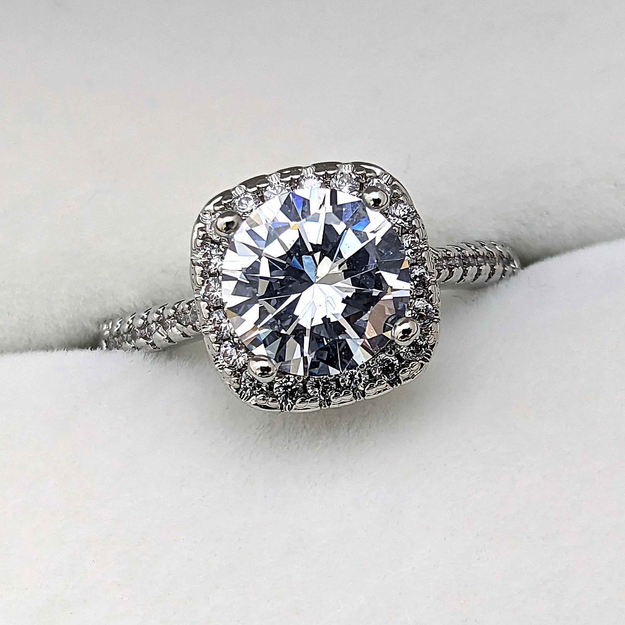 ２カラットの輝くダイヤモンドを囲むダイヤモンドで太陽が輝くような婚約指輪
